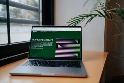 Ein Laptop mit ChatGPT auf einem Schreibtisch am Fenster in einem modernen Homeoffice.