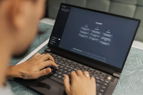 Nahaufnahme einer Person, die auf einem Laptop mit der ChatGPT-Oberfl&auml;che tippt, als Sinnbild moderner Technologienutzung.