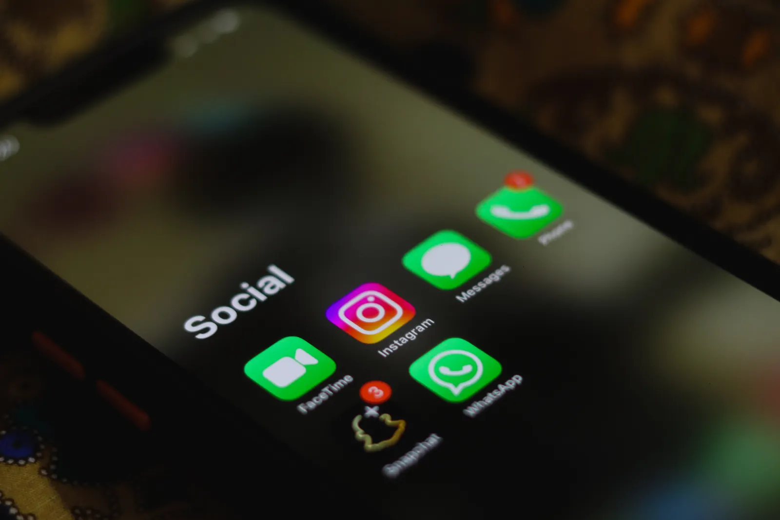 A close-up shot of smartphone displaying social media apps icons on screen.