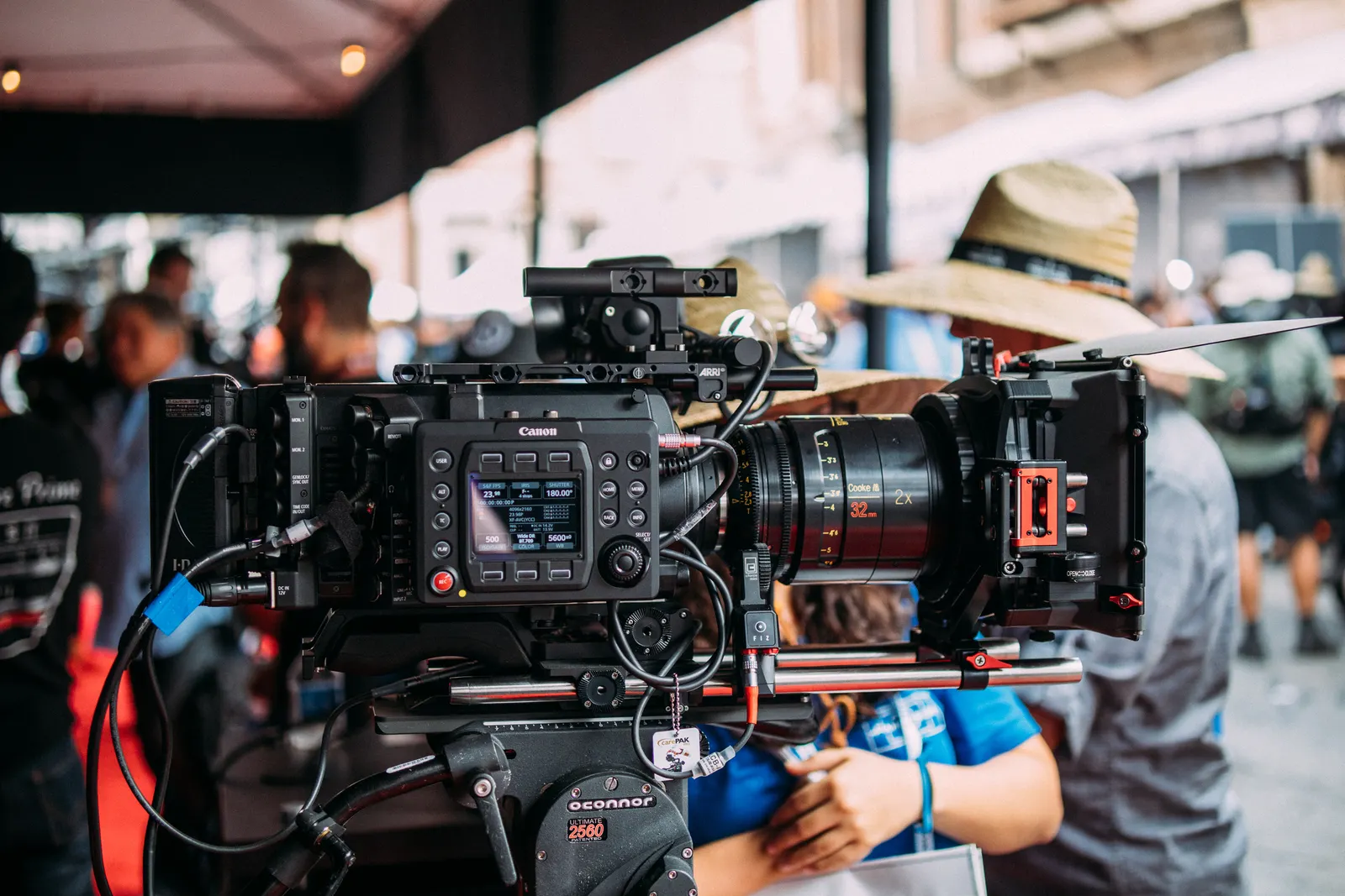 Close-up of a professional video camera setup at an outdoor event focusing on filmmaking equipment.