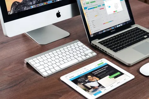 Ein eleganter B&uuml;roarbeitsplatz mit Apple-Ger&auml;ten: iMac, MacBook und iPad.