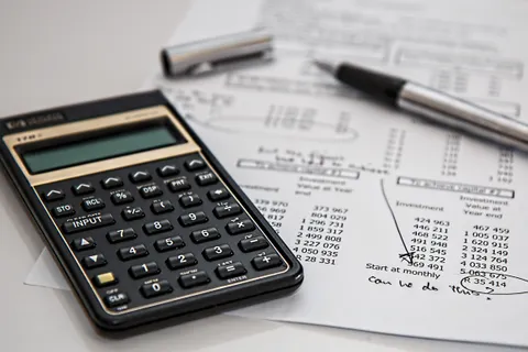 Nahaufnahme von Finanzunterlagen mit Taschenrechner und Stift, passend zu Themen der Unternehmensf&uuml;hrung.