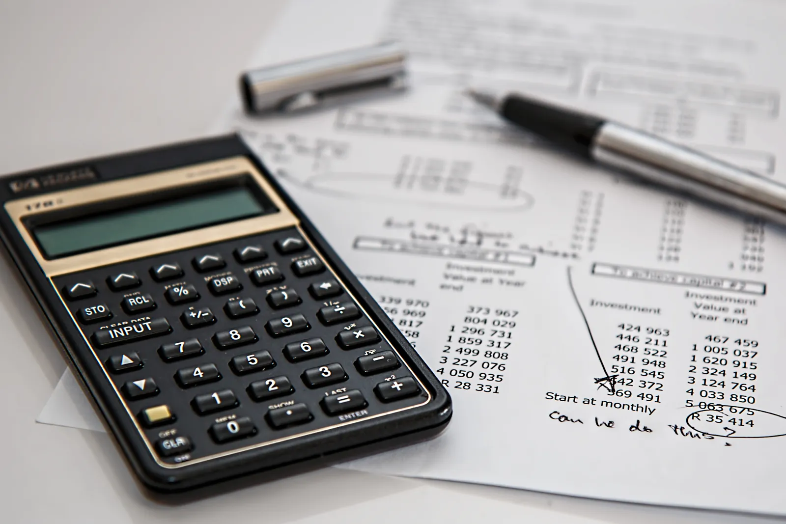 Close-up of financial documents with calculator and pen, ideal for business management themes.