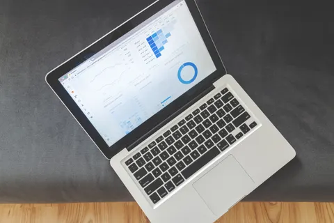Draufsicht auf einen Laptop mit Datenvisualisierungen und Diagrammen auf dem Bildschirm.