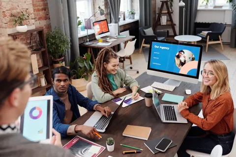 Ein vielf&auml;ltiges Team arbeitet in einem modernen B&uuml;ro mit digitalen Ger&auml;ten und Diagrammen gemeinsam an einem Projekt.