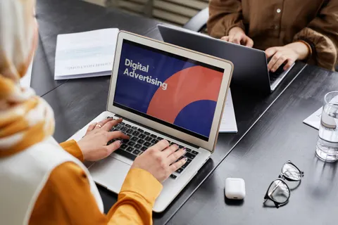 Zwei Fachleute besch&auml;ftigen sich im B&uuml;ro am Laptop mit digitaler Werbung.