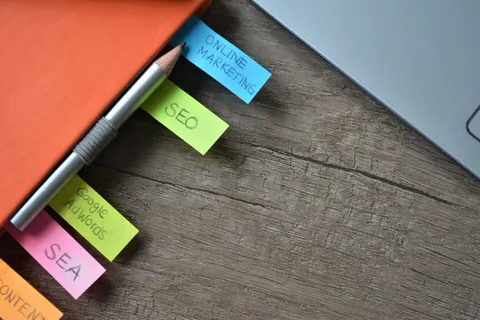 Nahaufnahme eines SEO-Strategieplaners mit bunten Haftnotizen und einem Bleistift auf einem Notizbuch.