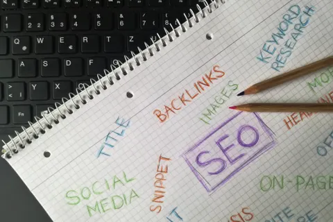 Nahaufnahme eines Notizbuchs mit SEO-Begriffen und Keywords, zum Thema digitale Marketingstrategie.